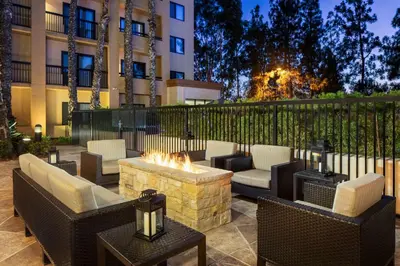 a patio with furniture and a fire pit in front of a building at Sonesta Select Laguna Hills Irvine Spectrum in Laguna Hills