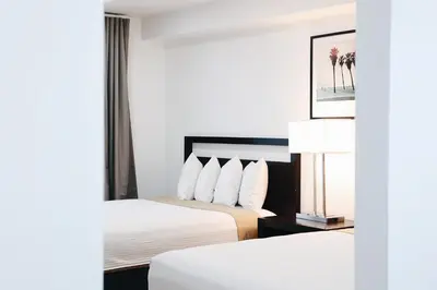 a hotel room with two beds and a lamp at Hotel Ash&9th in San Diego