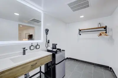 a white bathroom with a sink and a mirror at Hotel Ash&9th in San Diego