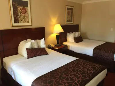 a hotel room with two beds and a lamp at Chula Vista Inn in Chula Vista