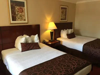 a hotel room with two beds and a lamp at Chula Vista Inn in Chula Vista