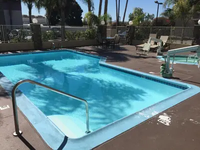 a large blue swimming pool with a rail around it at Chula Vista Inn in Chula Vista