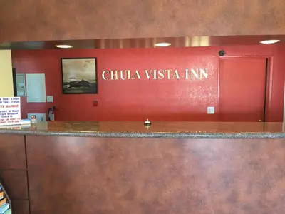 a sign that reads chihuahua vista inn on a red wall at Chula Vista Inn in Chula Vista