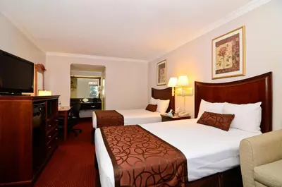 a hotel room with two beds and a flat screen tv at Chula Vista Inn in Chula Vista