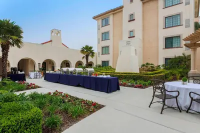 a courtyard with tables and chairs and a building at Courtyard San Diego Airport/Liberty Station in San Diego