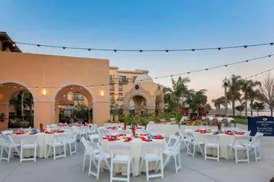 a group of tables and white chairs and a building at Courtyard San Diego Airport/Liberty Station in San Diego