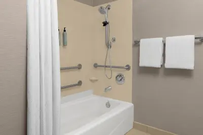 a bathroom with a tub and a shower with towels at Courtyard by Marriott San Diego Central in San Diego