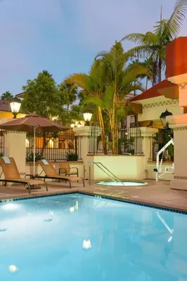 a swimming pool in front of a hotel with chairs at Courtyard San Diego Old Town in San Diego