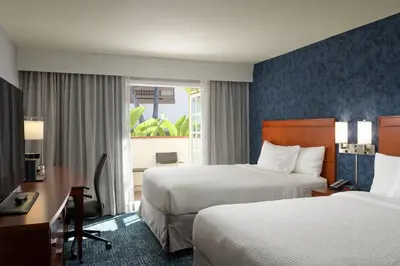 a hotel room with two beds and a desk at Courtyard San Diego Old Town in San Diego
