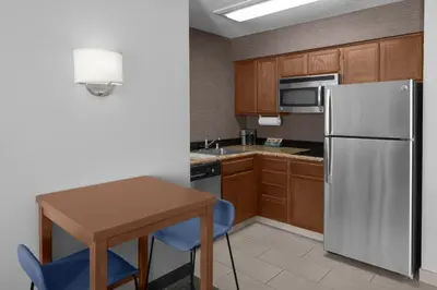 a kitchen with a white refrigerator and a wooden table at Residence Inn by Marriott San Diego Downtown in San Diego