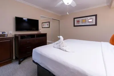 a bedroom with a bed and a flat screen tv at Coronado Beach Resort in San Diego