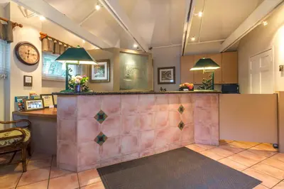 a bar in a lobby with a clock on the wall at San Clemente Cove Resort in San Clemente