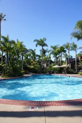 a large swimming pool with palm trees in the background at Humphreys Half Moon Inn in San Diego