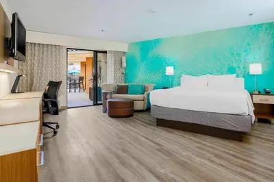 a hotel room with a bed and a living room at Courtyard by Marriott San Diego Del Mar/Solana Beach in Solana Beach