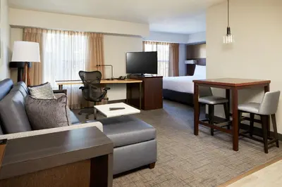a hotel room with a couch and a bed and a desk at Residence Inn San Diego Carlsbad in Carlsbad