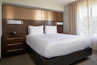 a bedroom with a large bed and a large window at Residence Inn San Diego Carlsbad in Carlsbad
