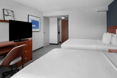 a hotel room with two beds and a flat screen tv at Courtyard by Marriott San Diego Rancho Bernardo in Rancho Bernardo