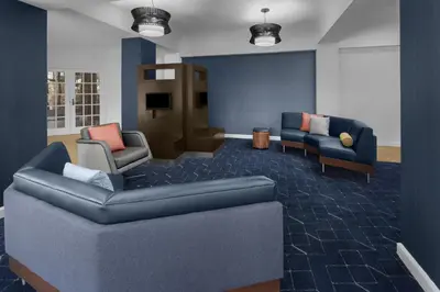 a waiting room with a couch and chairs and a tv at Courtyard by Marriott San Diego Rancho Bernardo in Rancho Bernardo