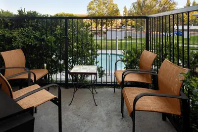 a patio with chairs and a table and a pool at Courtyard by Marriott San Diego Rancho Bernardo in Rancho Bernardo