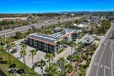 an aerial view of a building with palm trees and a road at Motel 6-Oceanside, CA in Oceanside
