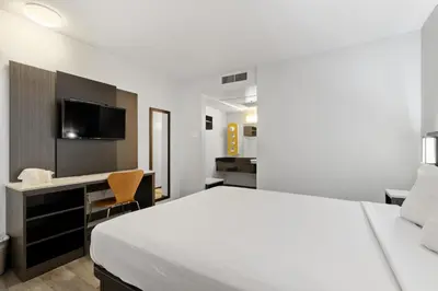 a bedroom with a bed and a desk with a television at Motel 6-Oceanside, CA in Oceanside