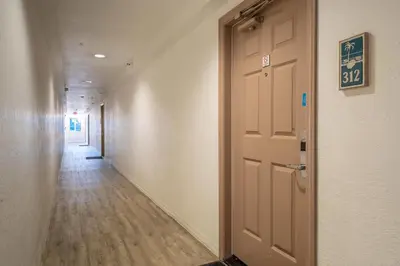 an empty hallway with a door and a hallwayngth at Southern California Beach Club in Oceanside