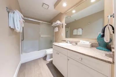 a bathroom with a sink and a toilet and a mirror at Southern California Beach Club in Oceanside