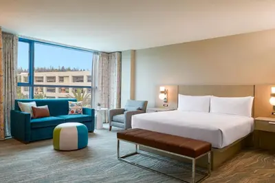 a hotel room with a bed and a couch and a chair at Renaissance ClubSport Aliso Viejo Laguna Beach Hotel in Aliso Viejo