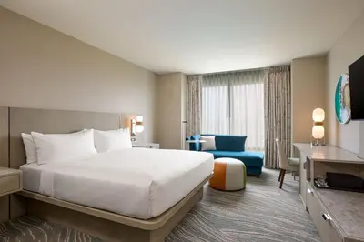 a hotel room with a large bed and a blue chair at Renaissance ClubSport Aliso Viejo Laguna Beach Hotel in Aliso Viejo