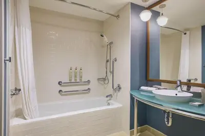 a bathroom with a tub and a sink and a shower at Renaissance ClubSport Aliso Viejo Laguna Beach Hotel in Aliso Viejo