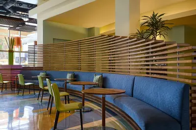 a restaurant with a blue couch and tables and chairs at Renaissance ClubSport Aliso Viejo Laguna Beach Hotel in Aliso Viejo