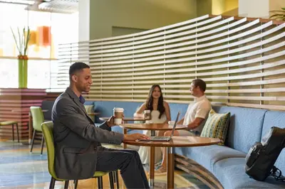 a group of people sitting at a table with laptops at Renaissance ClubSport Aliso Viejo Laguna Beach Hotel in Aliso Viejo