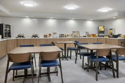 a restaurant with tables and chairs and a counter at Fairfield by Marriott Mission Viejo Orange County in Mission Viejo