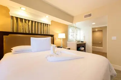 a bedroom with a white bed with towels on it at Carlsbad Seapointe Resort in Carlsbad