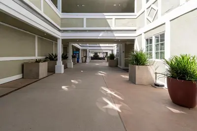 an empty hallway of a building with potted plants at Carlsbad Inn Beach Resort in Carlsbad