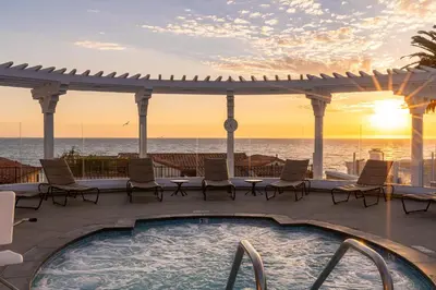 a hot tub on a deck with a view of the ocean at Carlsbad Inn Beach Resort in Carlsbad