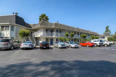 a parking lot with cars parked in front of a building at Motel 6-El Cajon, CA - San Diego in El Cajon