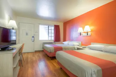 a hotel room with two beds and a flat screen tv at Motel 6-El Cajon, CA - San Diego in El Cajon