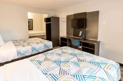 a hotel room with two beds and a desk at Motel 6-Carlsbad, CA - East Near LEGOLAND in Carlsbad