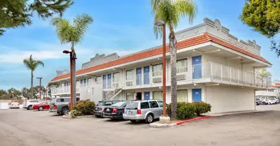 a building with cars parked in front of it at Motel 6-Carlsbad, CA - East Near LEGOLAND in Carlsbad