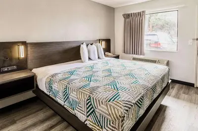 a hotel room with a bed with a quilt on it at Motel 6-Carlsbad, CA - East Near LEGOLAND in Carlsbad