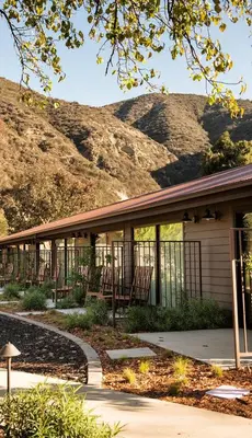 a building with chairs and a mountain in the background at The Ranch at Laguna Beach in Laguna Beach