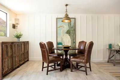 a dining room with a table and chairs and a painting at The Ranch at Laguna Beach in Laguna Beach