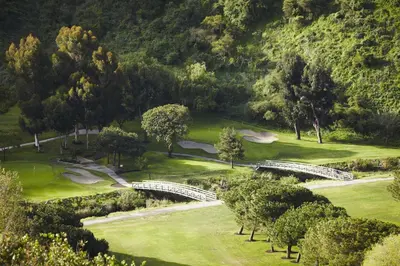 a view of a golf course with trees and a bridge at The Ranch at Laguna Beach in Laguna Beach
