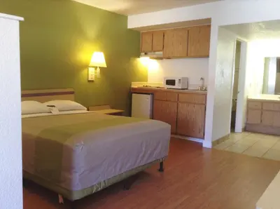 a bedroom with a bed and a kitchen at Motel 6 Hemet in Hemet