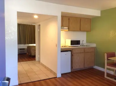 a kitchen and living room with green walls and a counter top at Motel 6 Hemet in Hemet