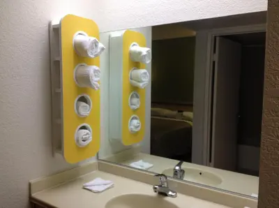 a bathroom mirror with a sink and towels at Motel 6 Hemet in Hemet