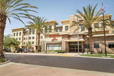 a hotel with palm trees in front of it at Residence Inn San Diego North/San Marcos in San Marcos