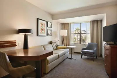 a living room with a couch and a table and a television at Residence Inn San Diego North/San Marcos in San Marcos