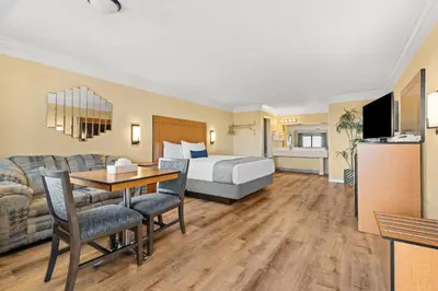 a hotel room with a bed and a table and a couch at Travelodge by Wyndham San Clemente Beach in San Clemente